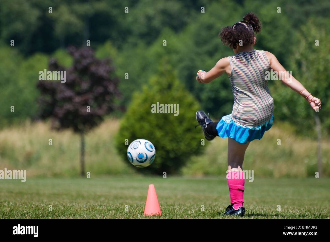 A girl practices kicking the soccer ball at summer soccer camp in Tumwater, Washington. Stock Photo