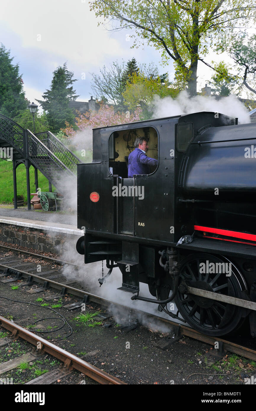 Engine driver in steam engine / locomotive at the Boat of Garten railway station, Scotland, UK Stock Photo