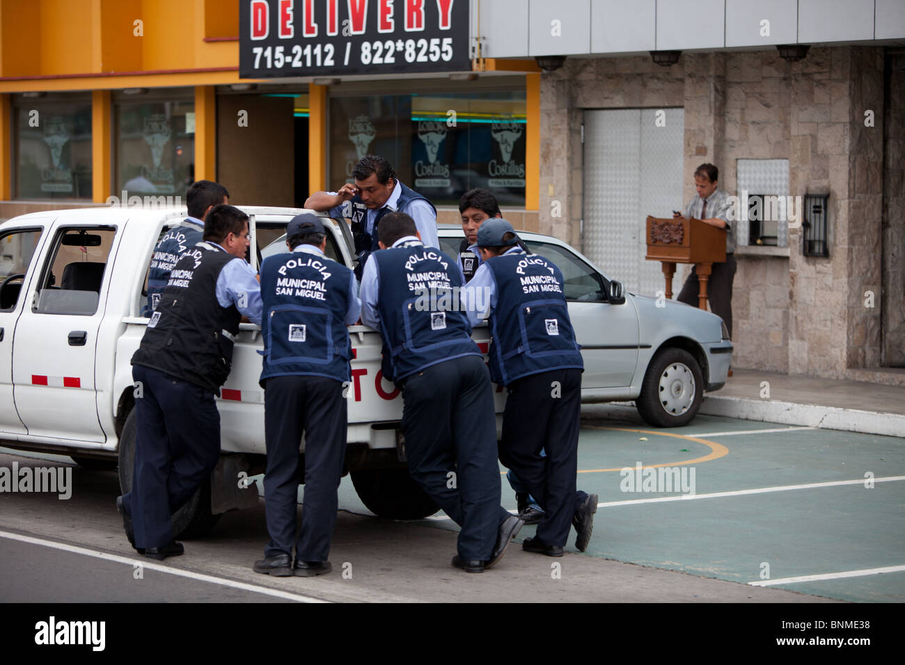 Policemen discussing business around a pickup in Lima, Peru Stock Photo