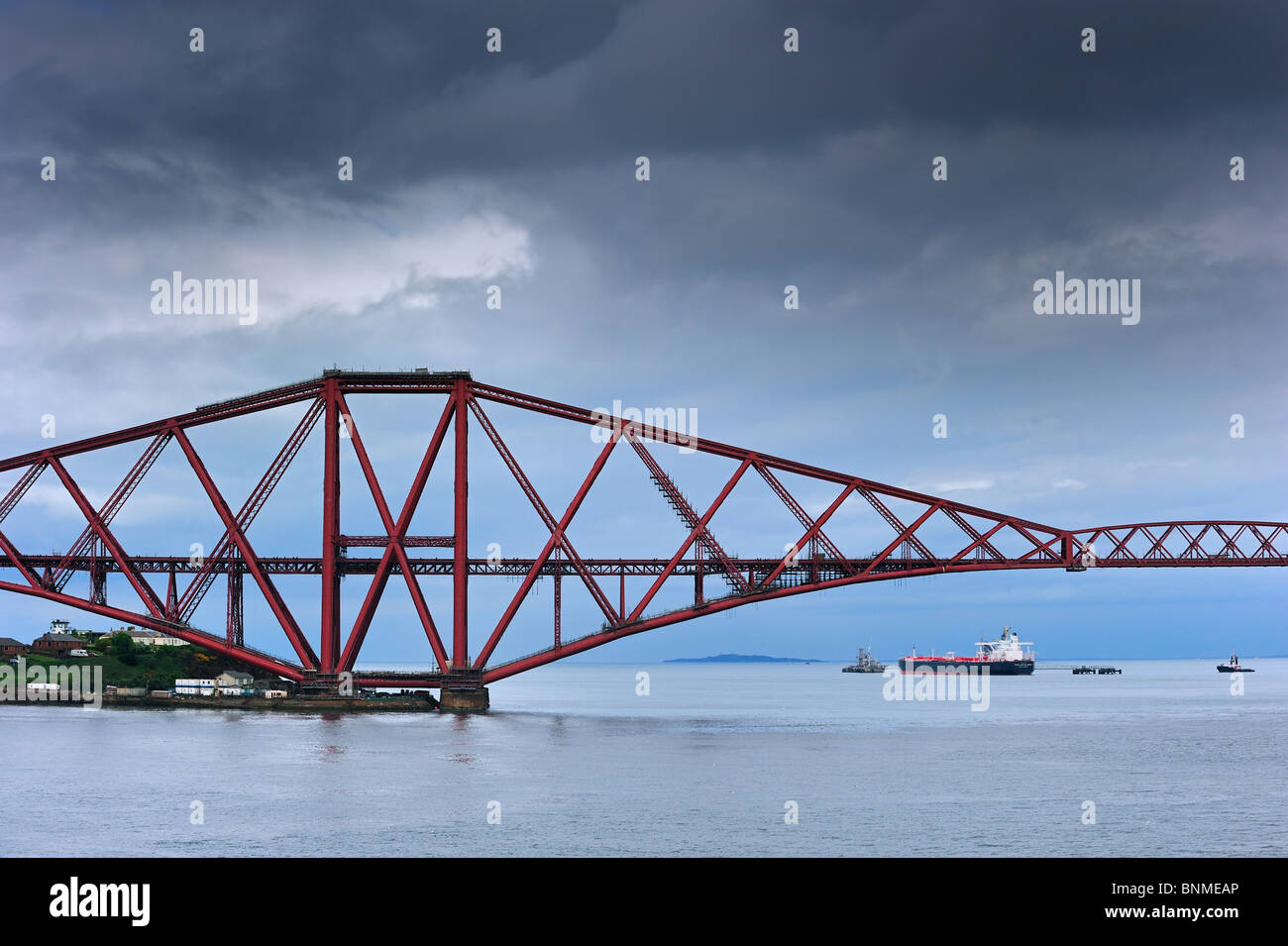 Oil tanker sailing under the Forth Railway Bridge / Forth Rail Bridge, a bridge over the Firth of Forth near Edinburgh, Scotland Stock Photo