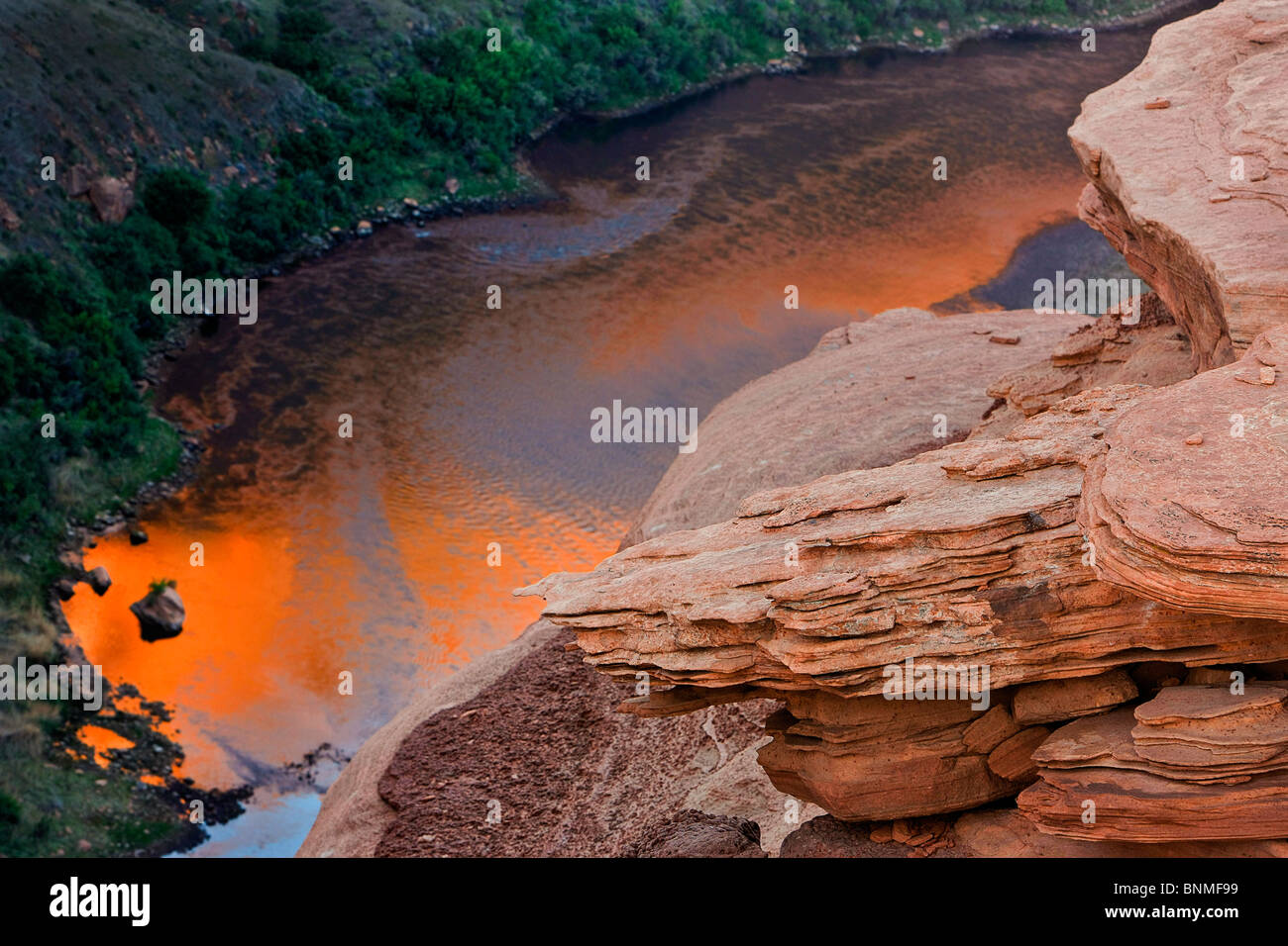 Early sunrise light is reflected into a bend of the Colorado River at Horseshoe Bend near Page, Arizona, USA. Stock Photo