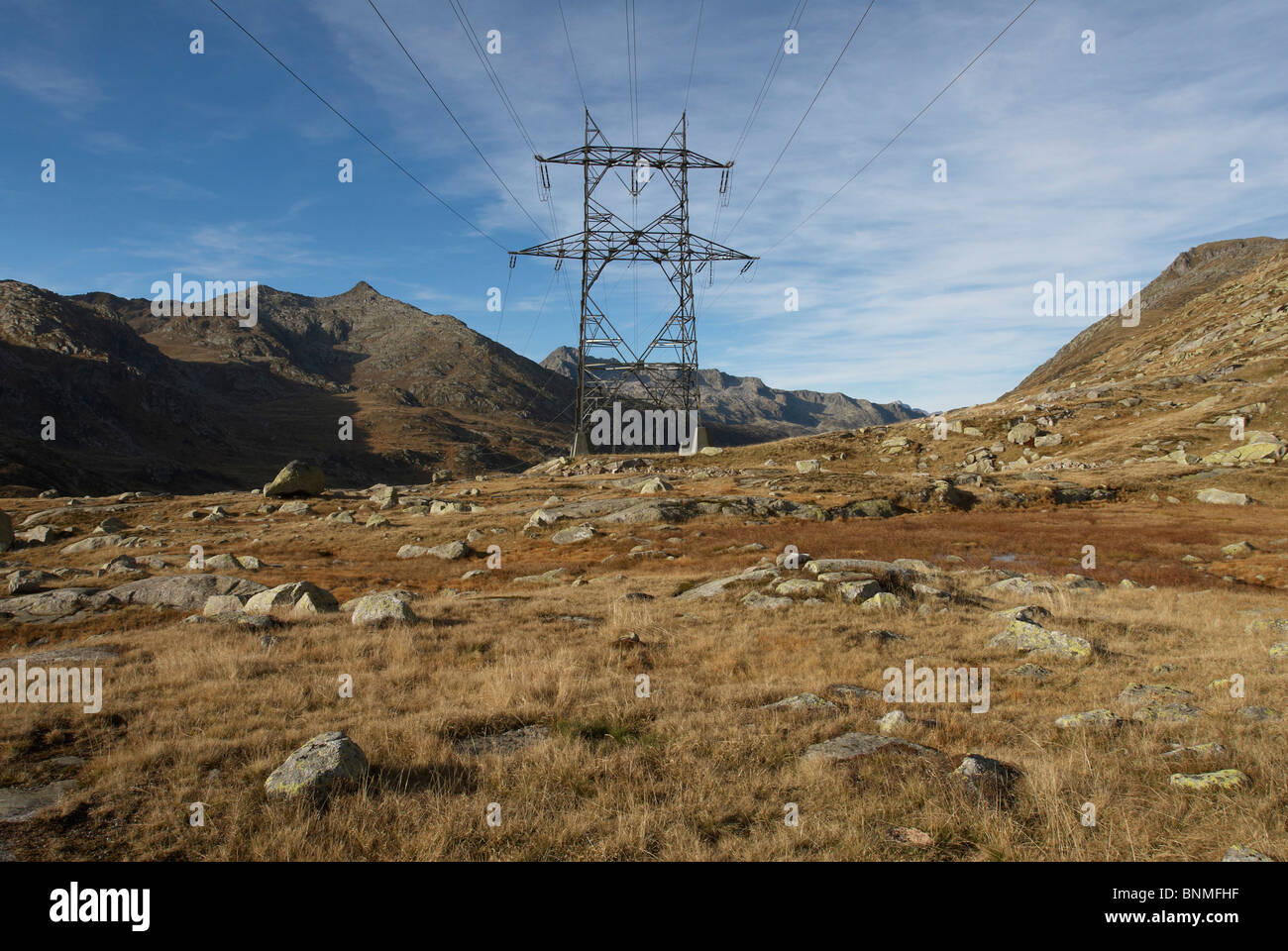 Switzerland Gotthard stream mast electric high voltage industry stream current mountains rocks cliffs autumn sky stones energy Stock Photo