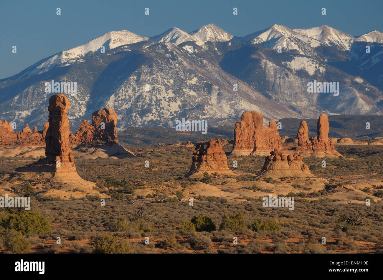 Rock Pinnacles La Sal Mountains mountains snow rock stone formation National Park landscape nature sky sunlight Arches National Stock Photo