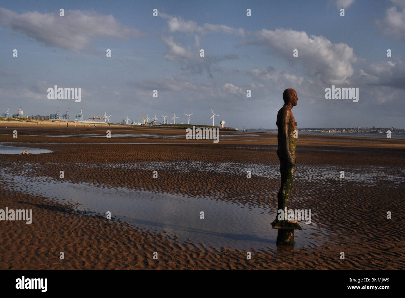 ANTONY GORMLEY STATUE ON CROSBY BEACH WITH BACKGROUND OF LIVERPOOL