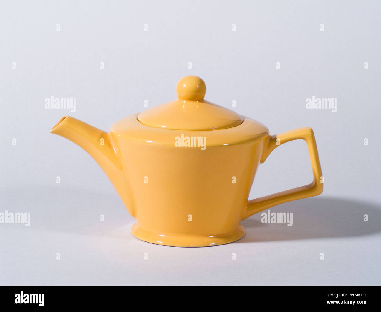 Yellow Teapot on Grey Background Stock Photo