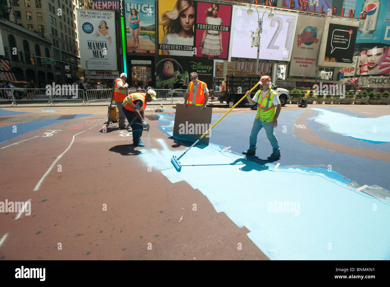 Workers from the Times Square Alliance paint 'Cool Water, Hot Island' in a plaza in Times Square in New York Stock Photo