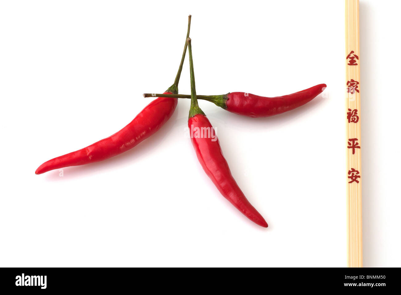 3 Chilli's and a chopstick Stock Photo
