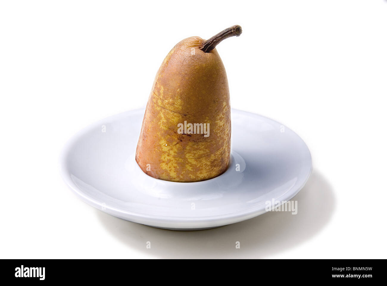 half pear stand in a small white porcelain plate Stock Photo