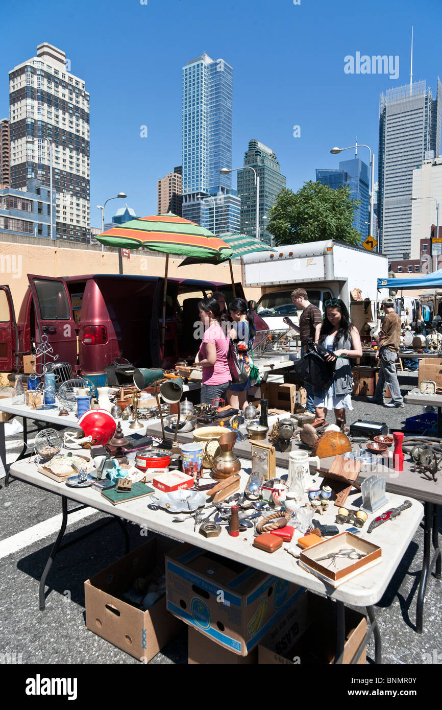 customers browse tables displaying a rare mixture of tchotchkes & treasures at Hells Kitchen weekend flea market New York City Stock Photo
