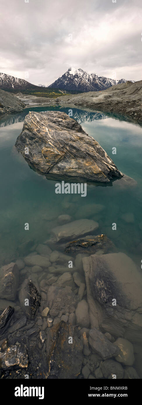 Stranded Glacial Erratic In A Pool Of Water With Snowcapped Chugach Mountains In The Background 