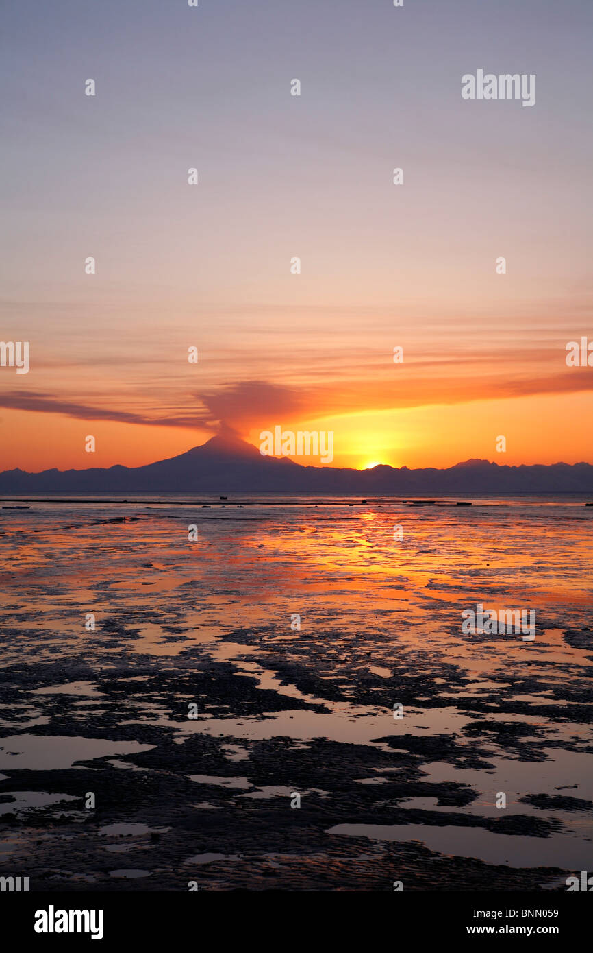 Ash cloud rises from Mt. Redoubt at sunset during low tide near