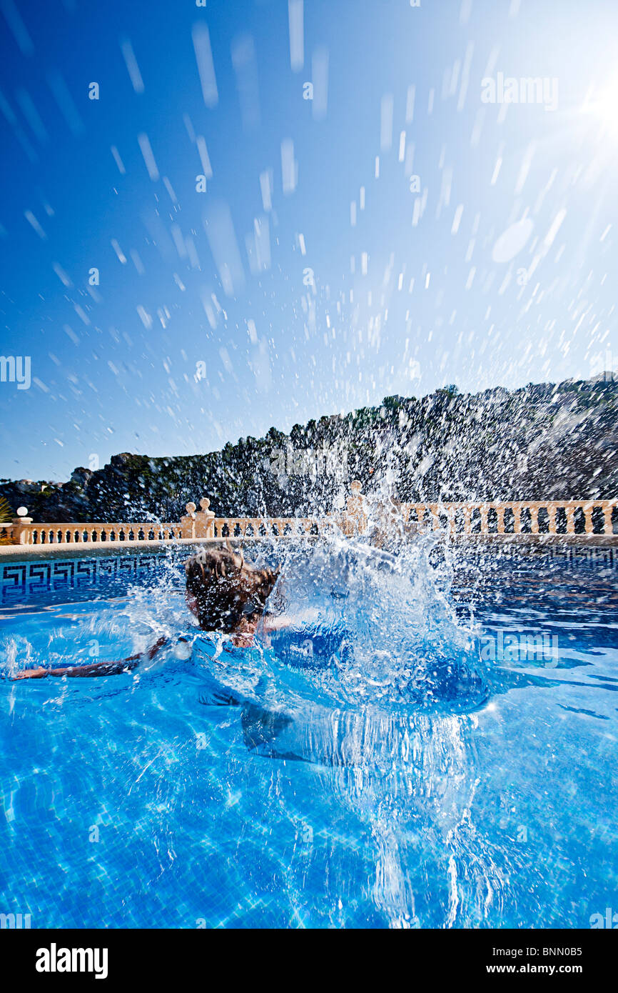 Shot of a Six Year Old Child Jumping into a Swimming Pool. Stock Photo