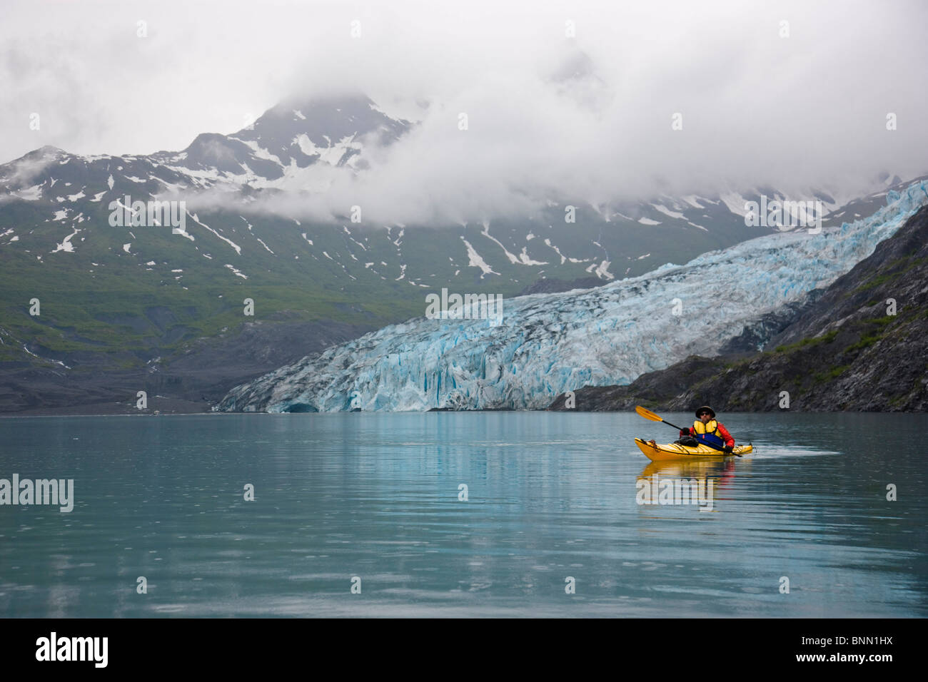 Man kayaking in Shoup Bay with Shoup Glacier in the background, Shoup Bay State Marine Park, Prince William Sound Alaska Stock Photo