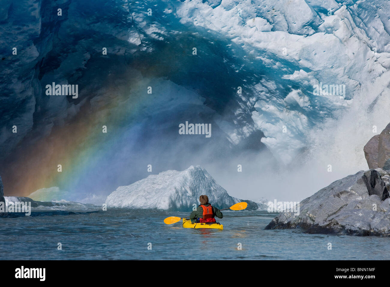 A kayaker explores a melt stream gushing from beneath Mendenhall Glacier, Mendenhall Lake, Tongass National Forest, Alaska Stock Photo