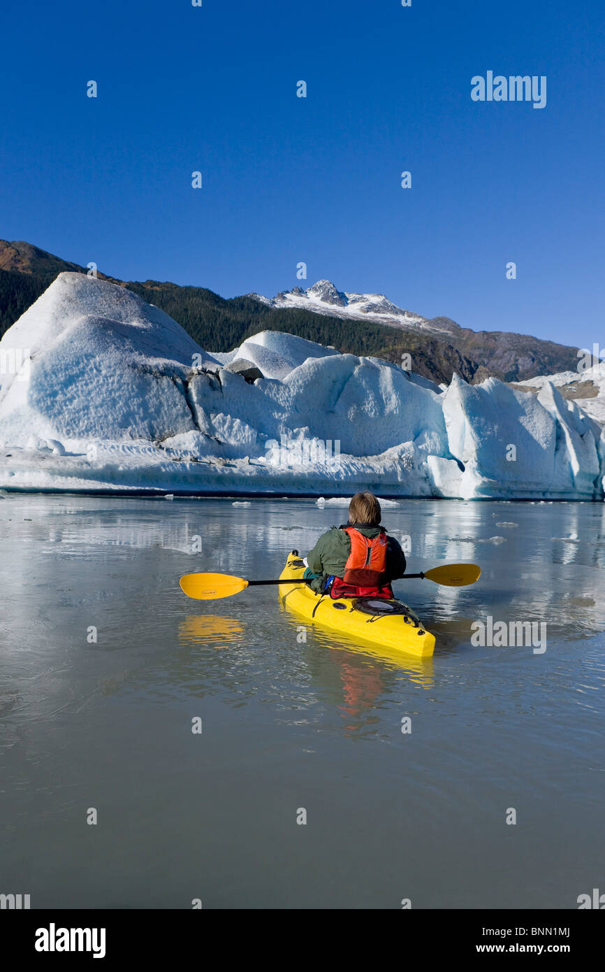 A kayaker paddles the icy waters of Mendenhall Lake with Mendenhall Glacier and Mt. Stroller White in the background, Alaska Stock Photo