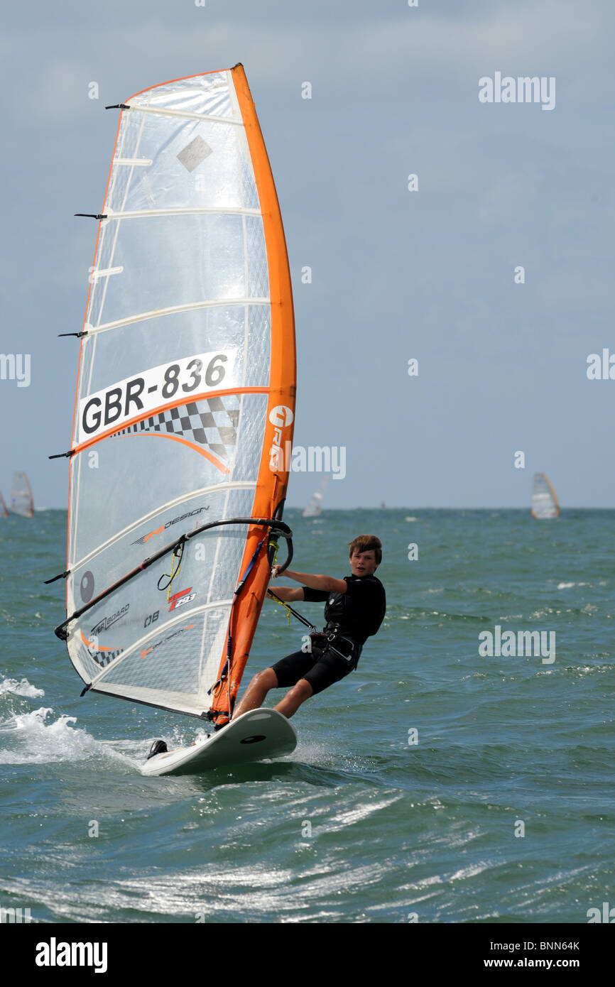 young windsurfer  hooked in and going for it , the board is planing  as he heads straight towards the camera Stock Photo