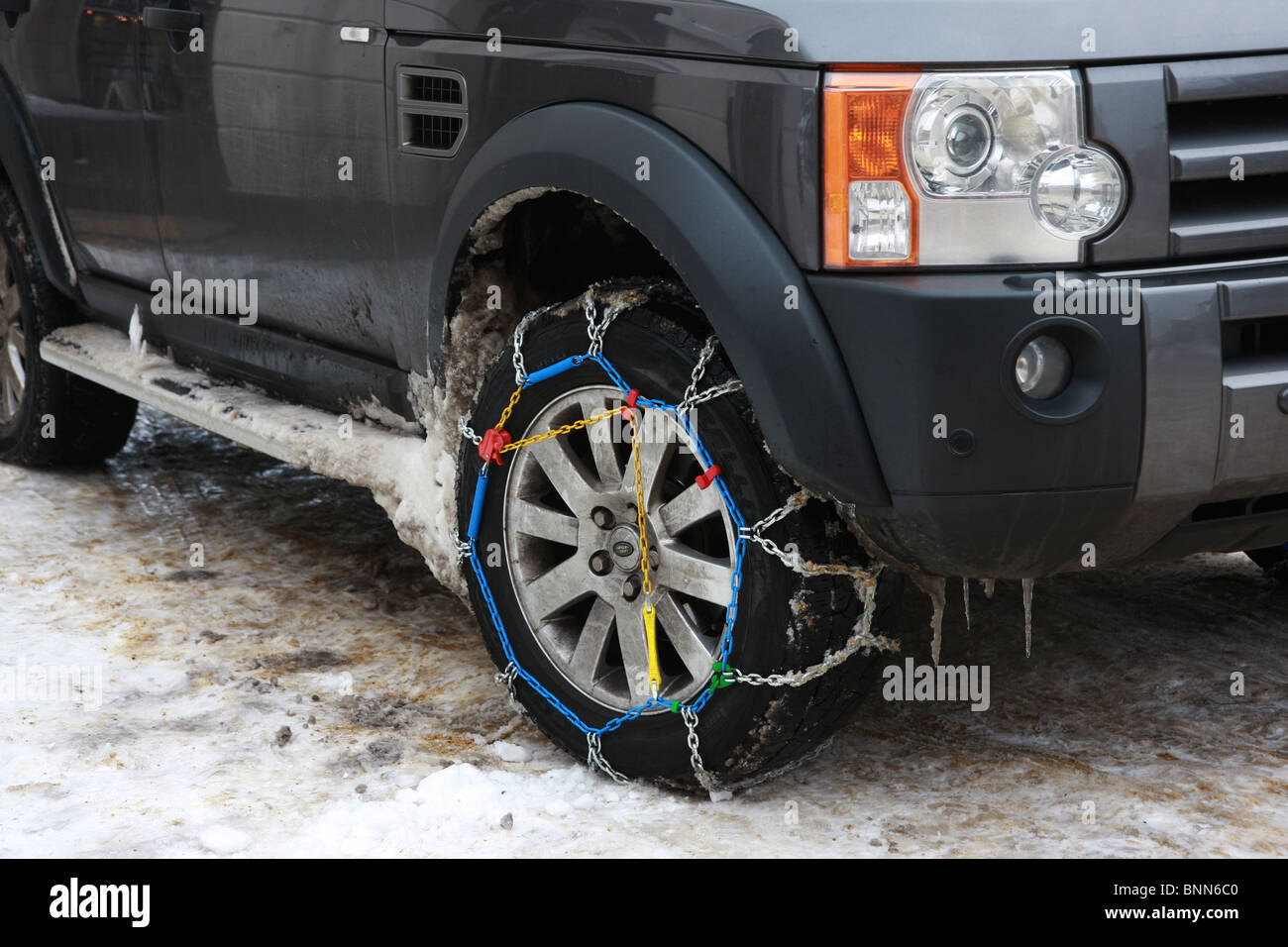 Snow chains fitted to a 4x4 car Stock Photo Alamy