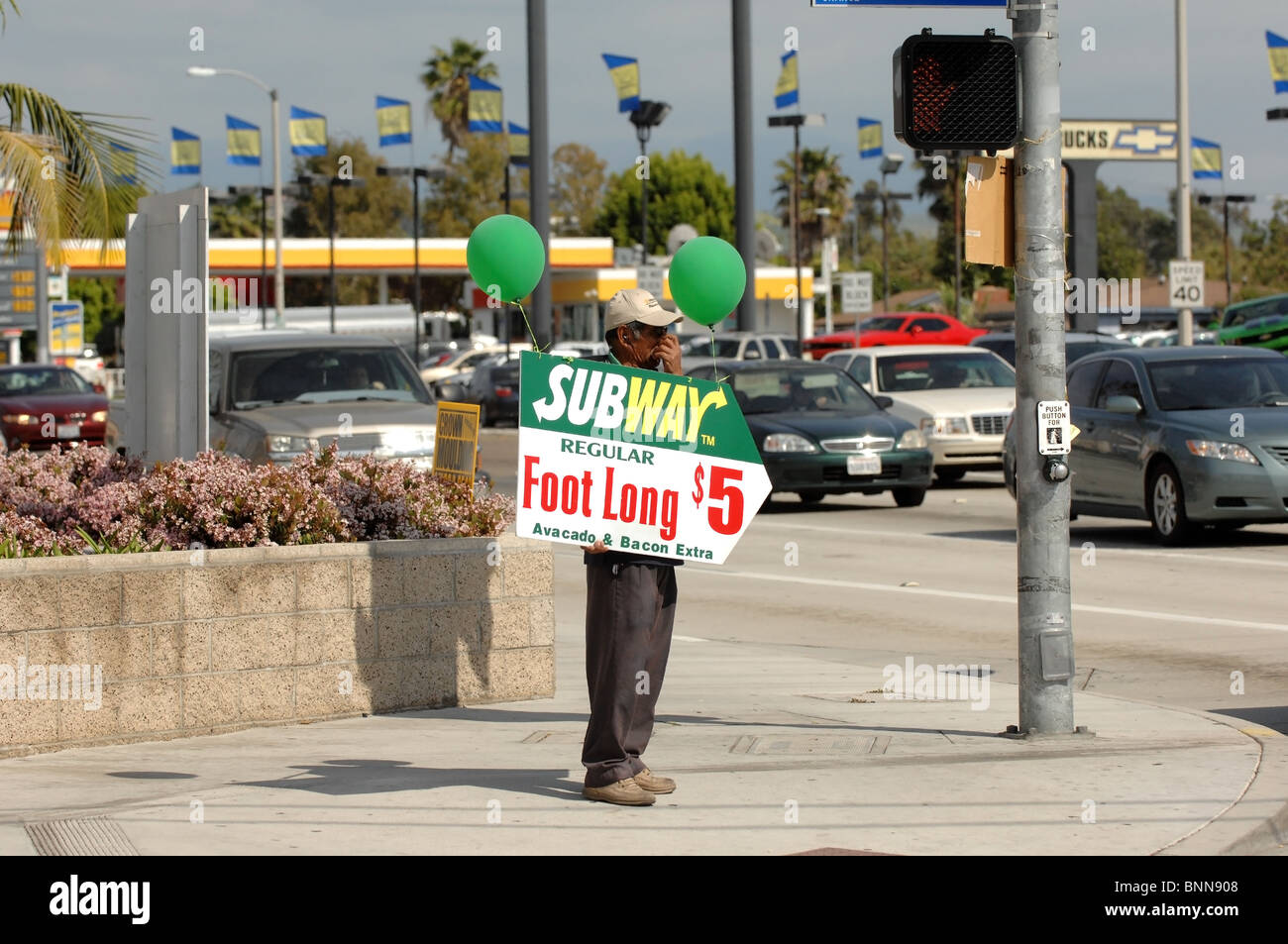 Human Billboard- A man holds an advertising sign on the corner of Chapman Avenue and Tustin in the city of Orange, CA. Stock Photo