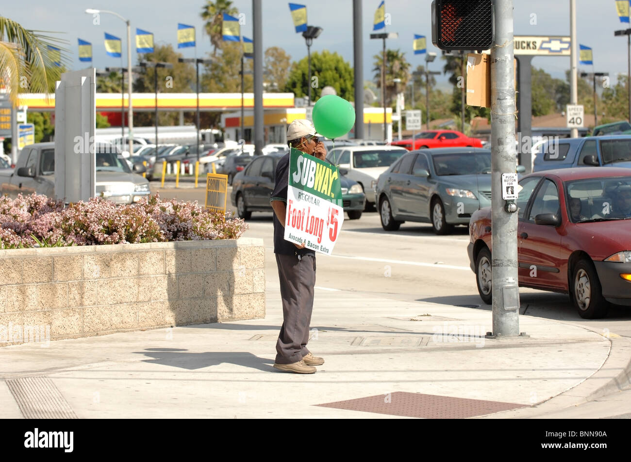 Human Billboard- A man holds an advertising sign on the corner of Chapman Avenue and Tustin in the city of Orange, CA. Stock Photo