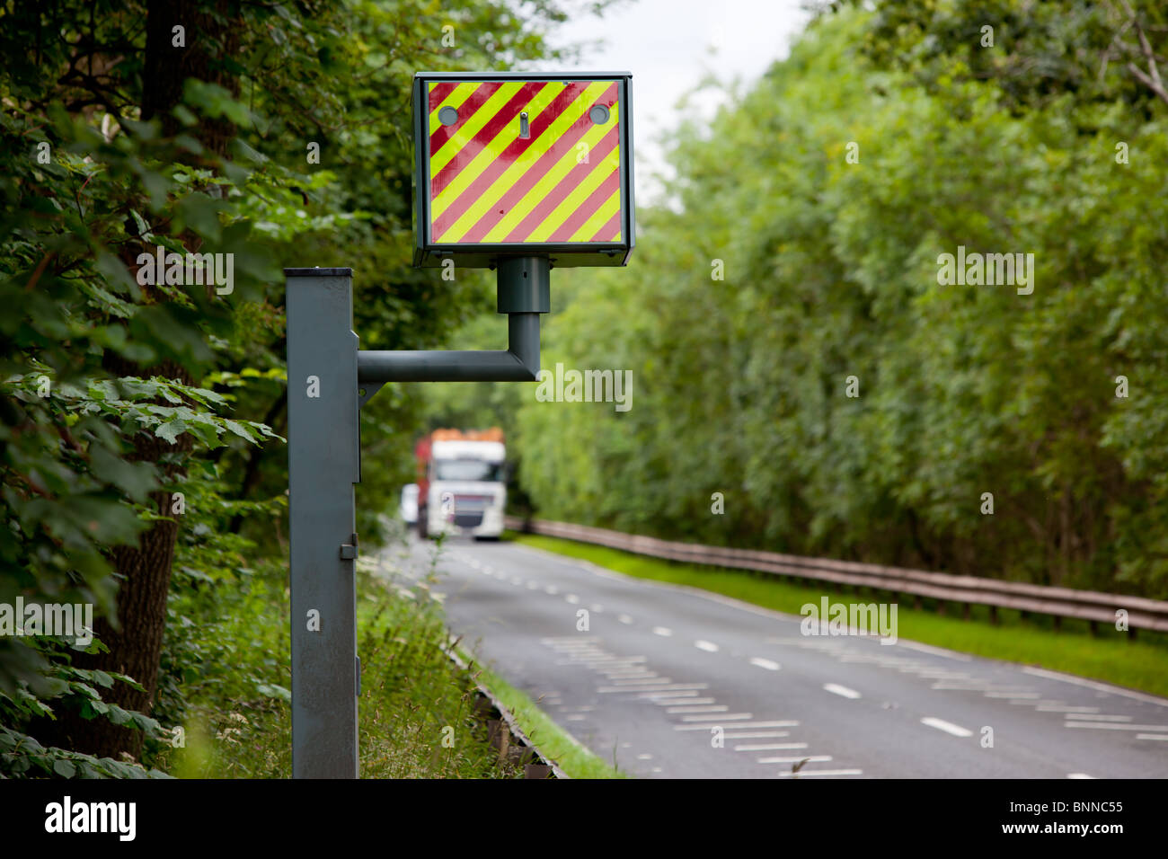 The back of a GATSO speed camera pointing up a road towards oncoming traffic Stock Photo
