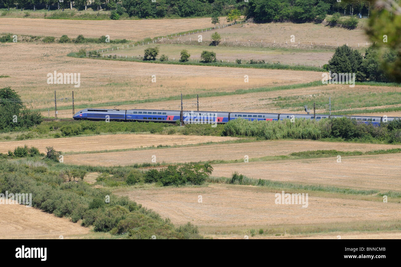 A French SNCF TGV passenger train in the countryside approaching Beziers in the Languedoc region of South of France Stock Photo