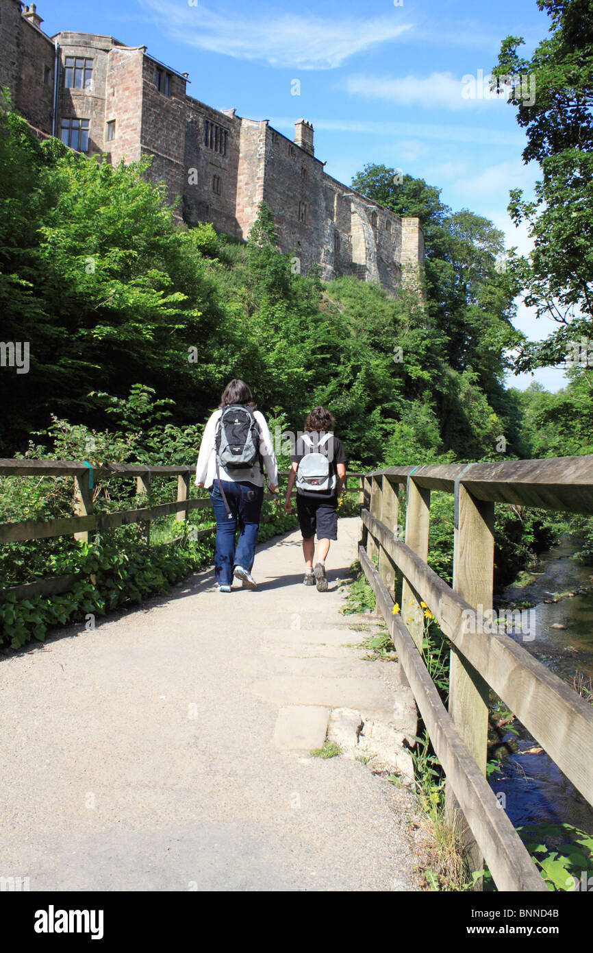 Backpackers on the pathway by Springs Branch Canal below the rear of Skipton Castle, Skipton, Yorkshire, England Stock Photo