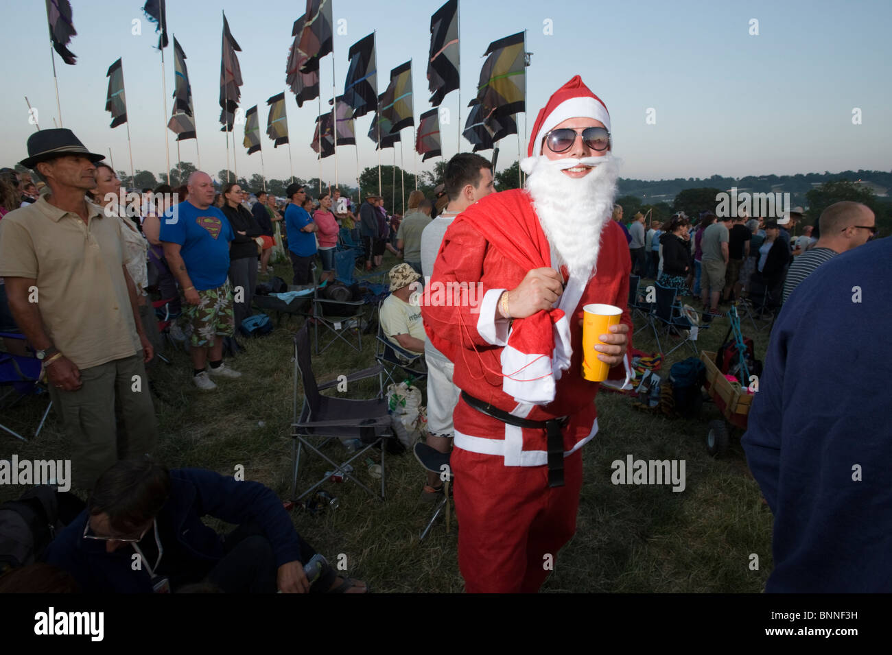 Glastonbury Festival. Man dressed in fancy dress costume as Father Christmas / Santa Claus in a crowd. Stock Photo