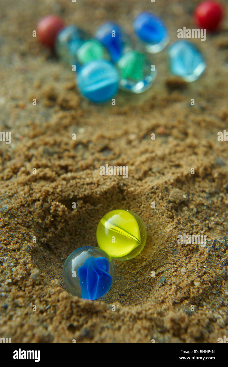 Playing with marbles on sand Stock Photo