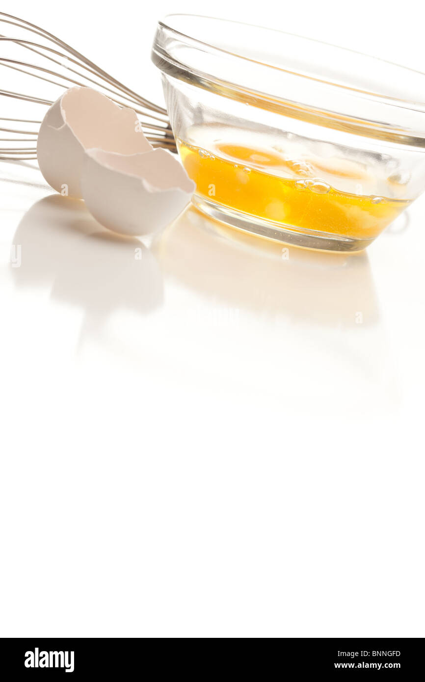 Hand Mixer with Eggs in a Glass Bowl on a Reflective White Background