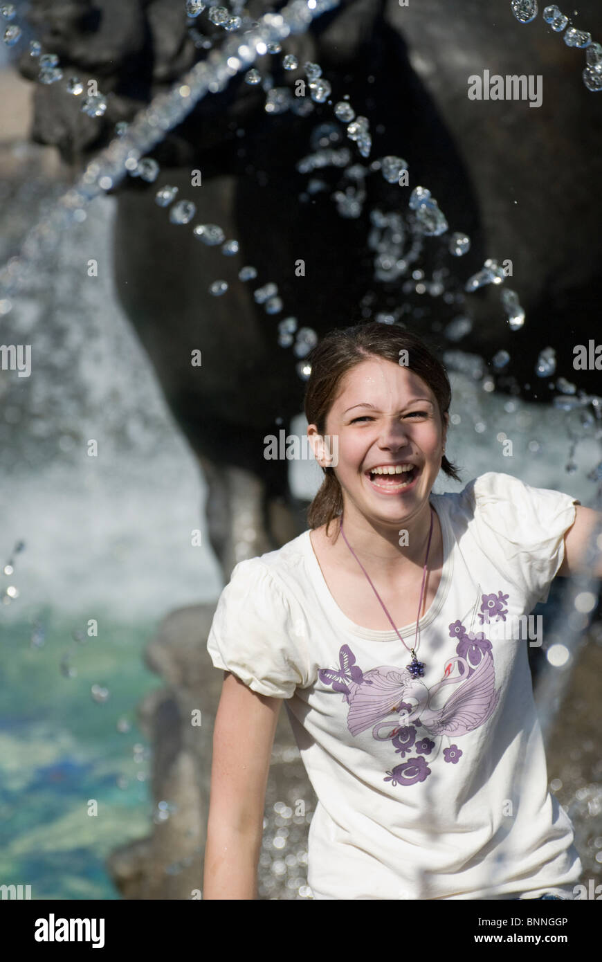Young girl playing close to city fountain Stock Photo - Alamy