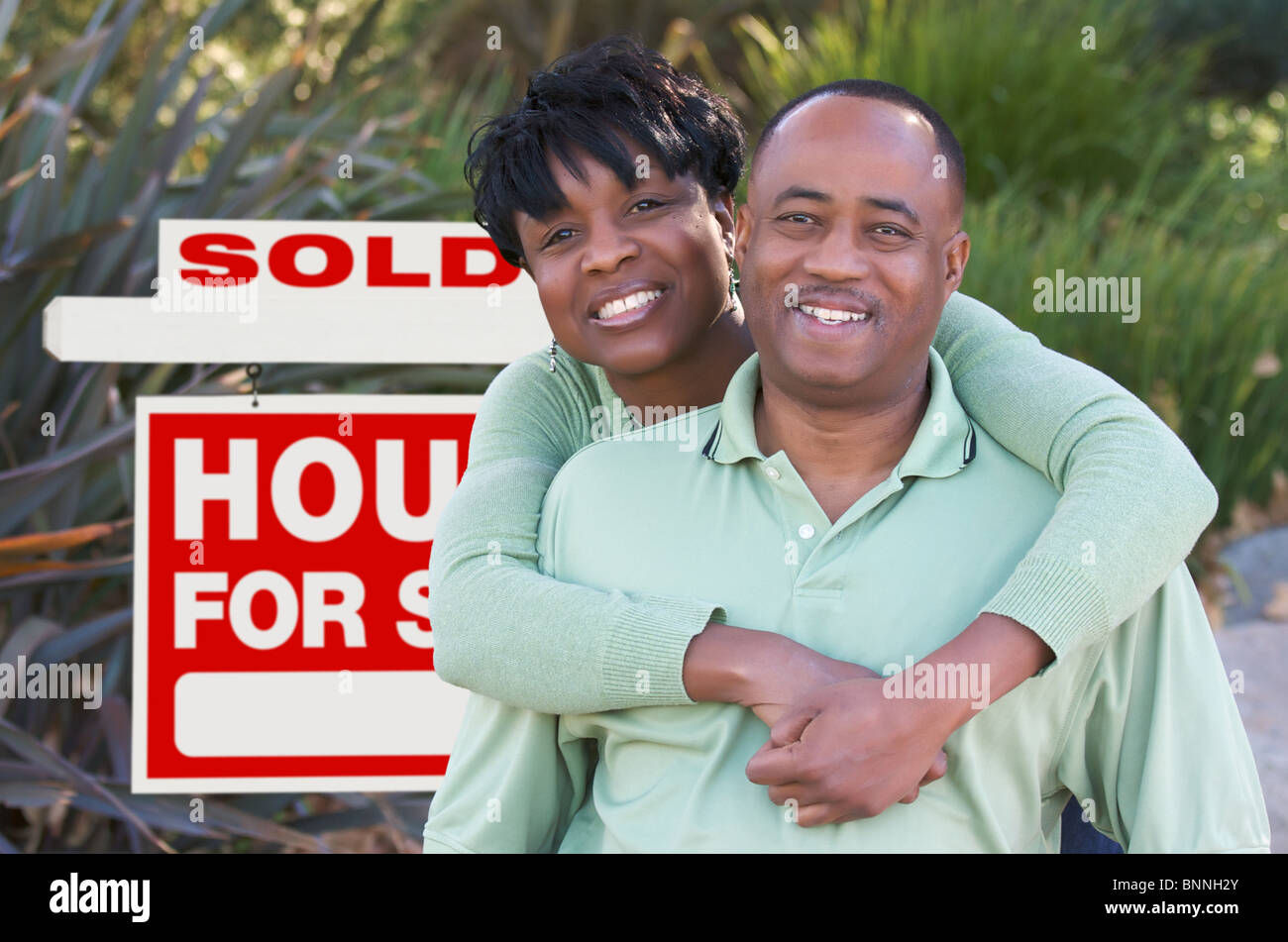 Happy African American Couple in Front of Sold Home For Sale Real ...