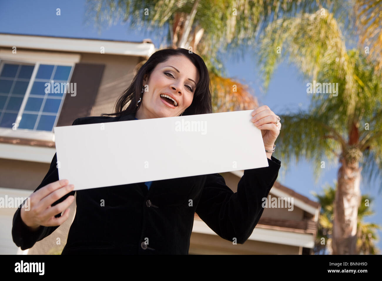 Happy Attractive Hispanic Woman Holding Blank Sign in Front of House ...