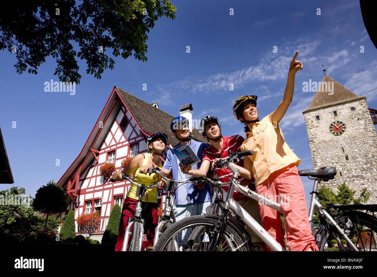 Switzerland swiss ride a bicycle group persons four show emperor's chair place steeple half-timbered house wheel bicycle Stock Photo