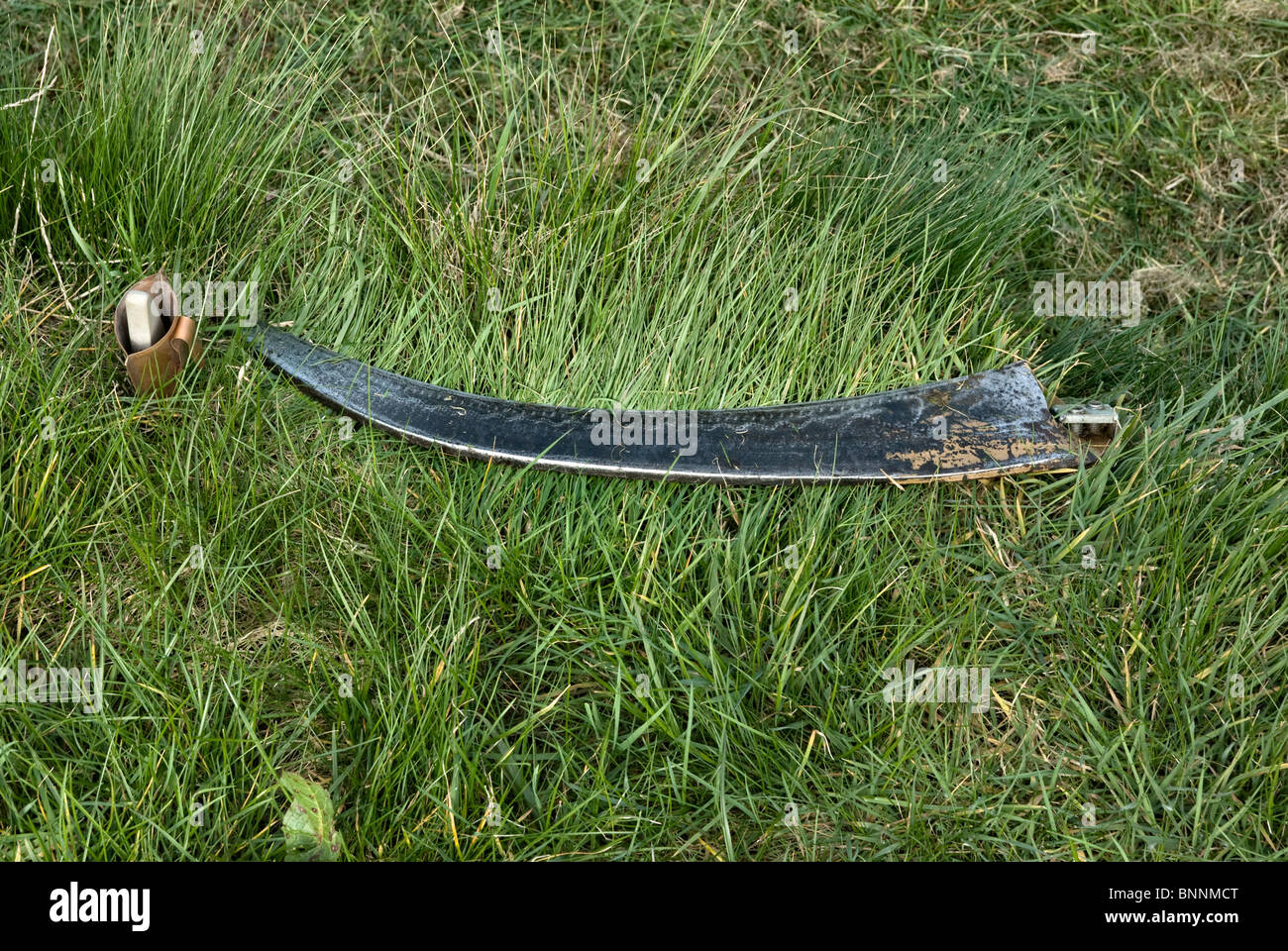 Scythe blade and sharpening stone Stock Photo Alamy