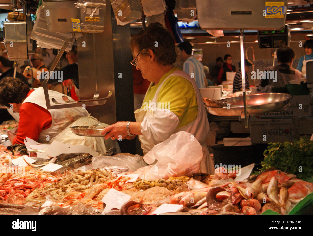 FISHMONGER FRESH FISH STALL AT LA BOQUERIA MARKET BARCELONA SPAIN Stock