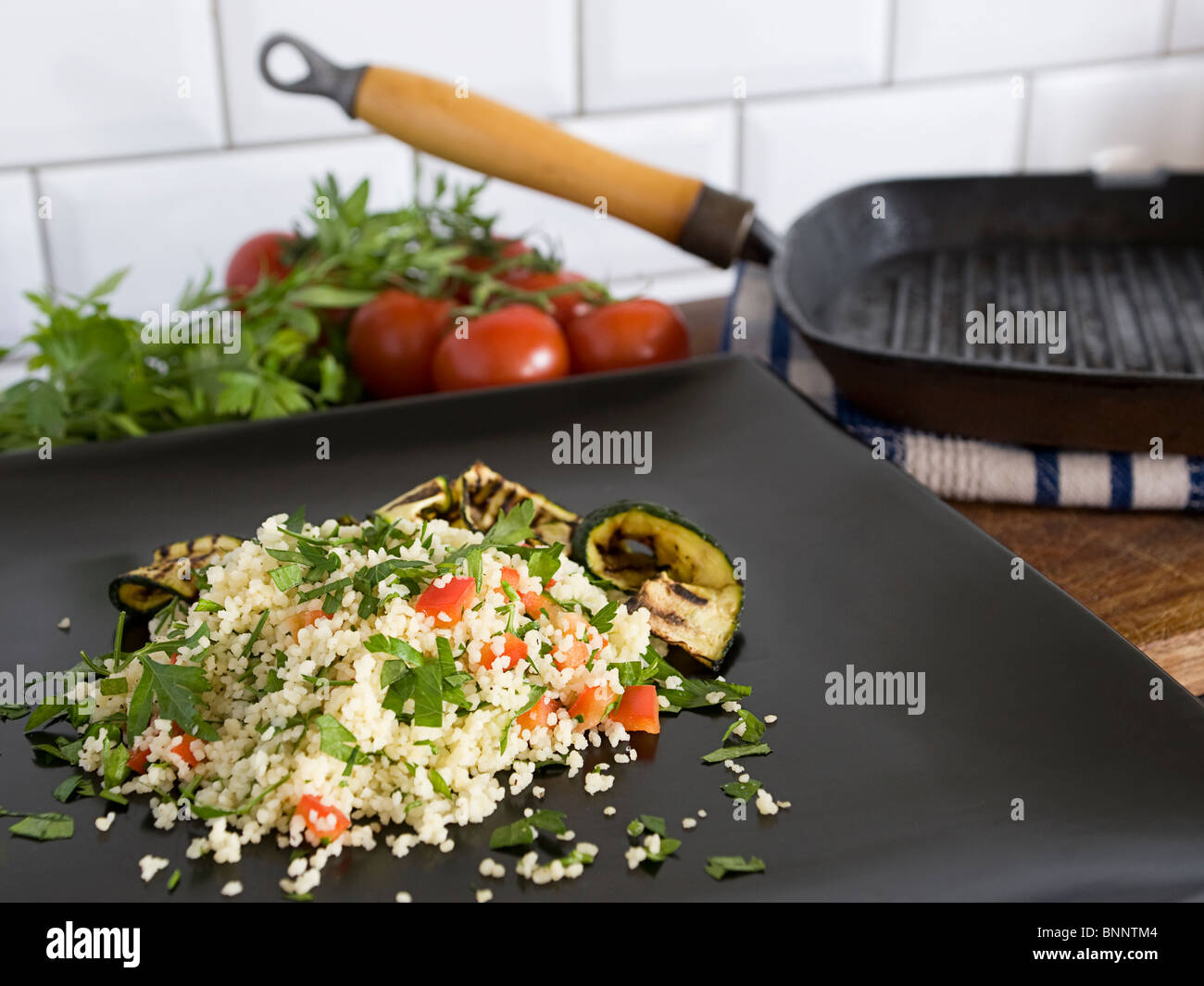 Couscous salad on a dark grey plate. Stock Photo