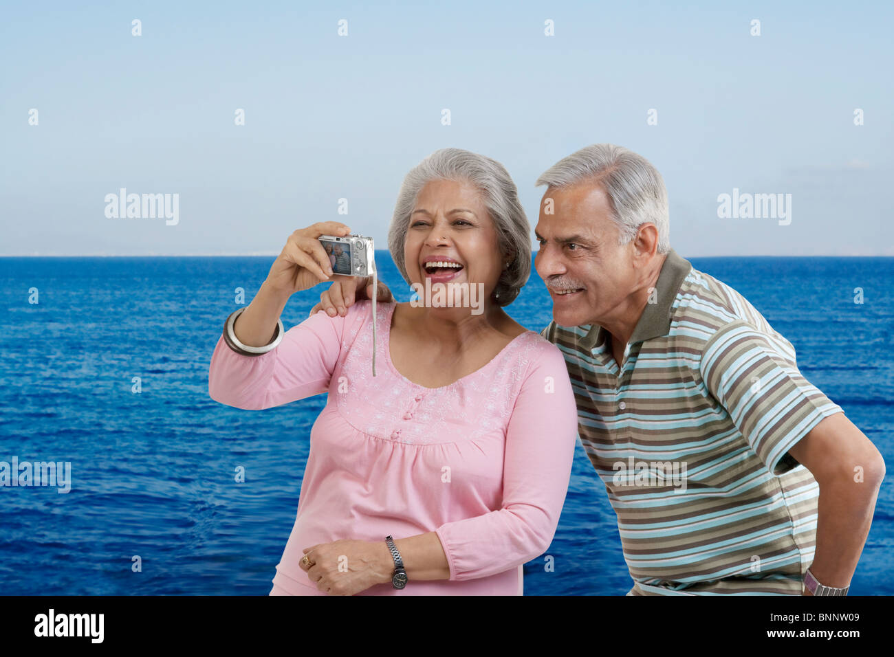 Couple looking at photographs in a camera Stock Photo