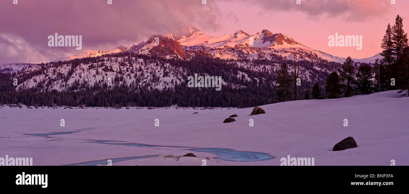 Spring thaw reveals blue ice and sunset light on mountains at Caples Lake, Carson Pass, California, USA. Stock Photo