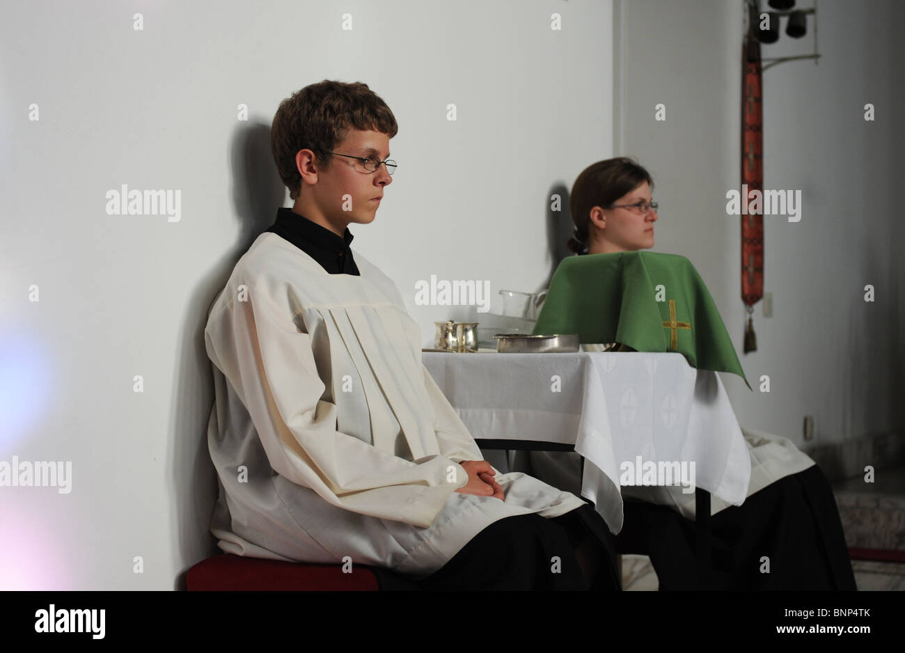 An altar boy at a christening at St. Joseph's Church, Berlin, Germany Stock Photo