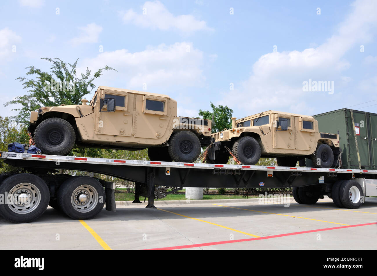 US military trucks being transported on large truck Stock Photo