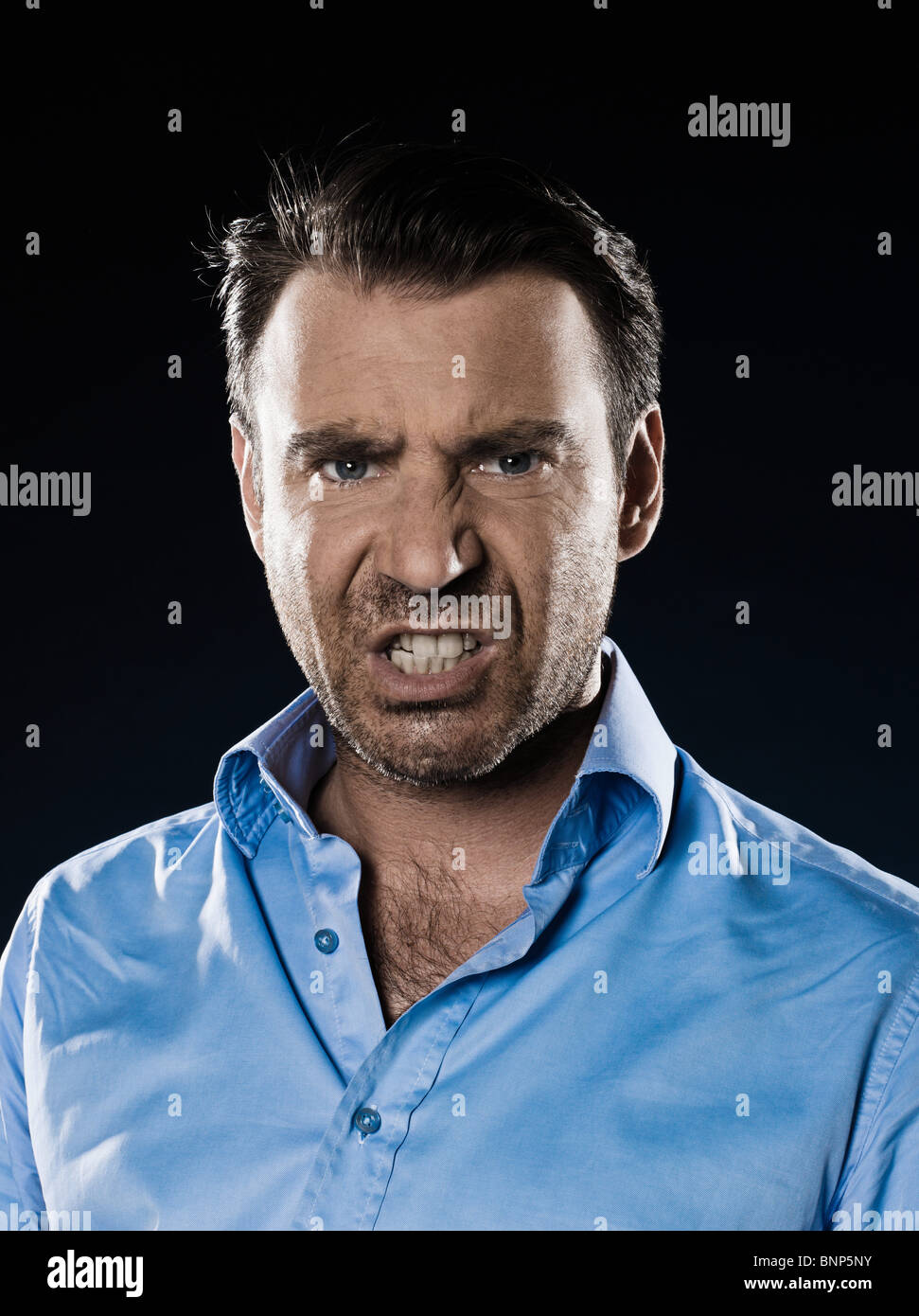 caucasian man unshaven pucker anger portrait isolated studio on black background Stock Photo