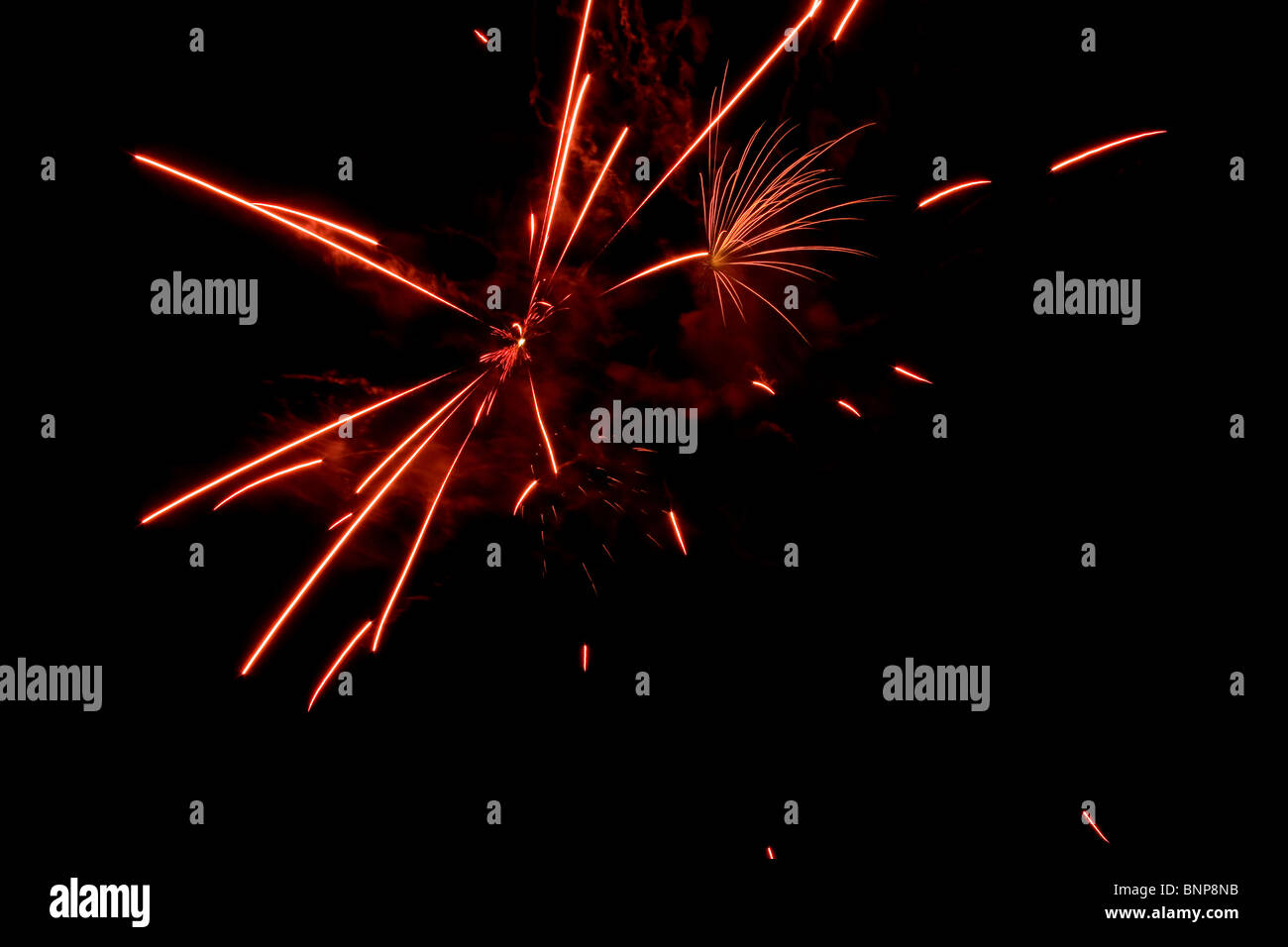 Red fireworks exploding in clouds of smoke Stock Photo - Alamy