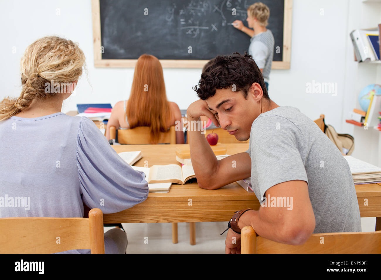 Tired teenager getting bored in a class Stock Photo - Alamy