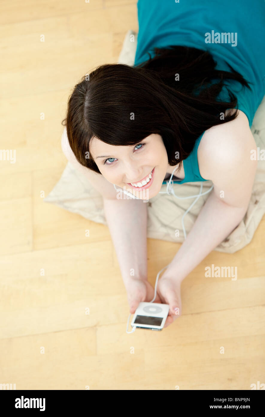 Relaxed woman listening music lying down on the floor Stock Photo - Alamy