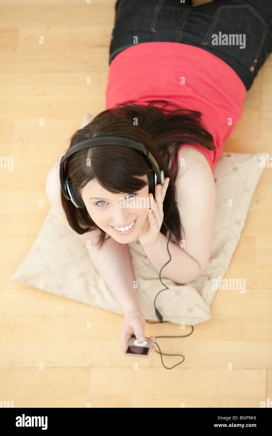 Merry woman listening music lying down on the floor Stock Photo - Alamy