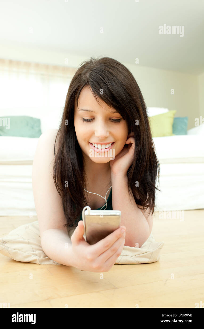 Pretty woman listening music lying on the floor Stock Photo - Alamy