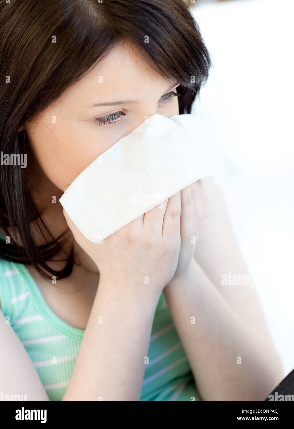 Portrait of a sick brunette teen girl blowing Stock Photo