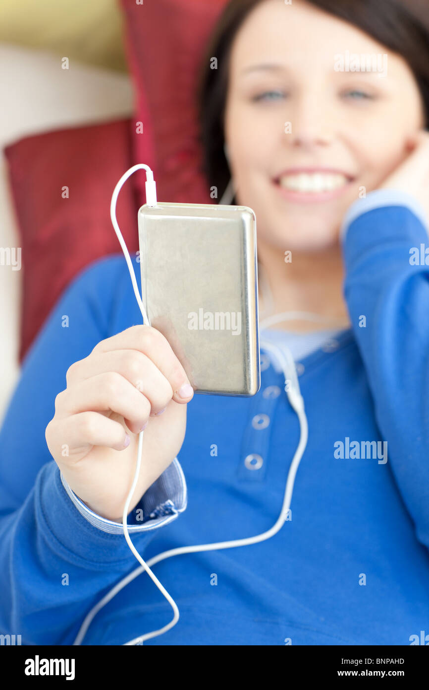 Cute young woman listening music lying on a sofa Stock Photo - Alamy