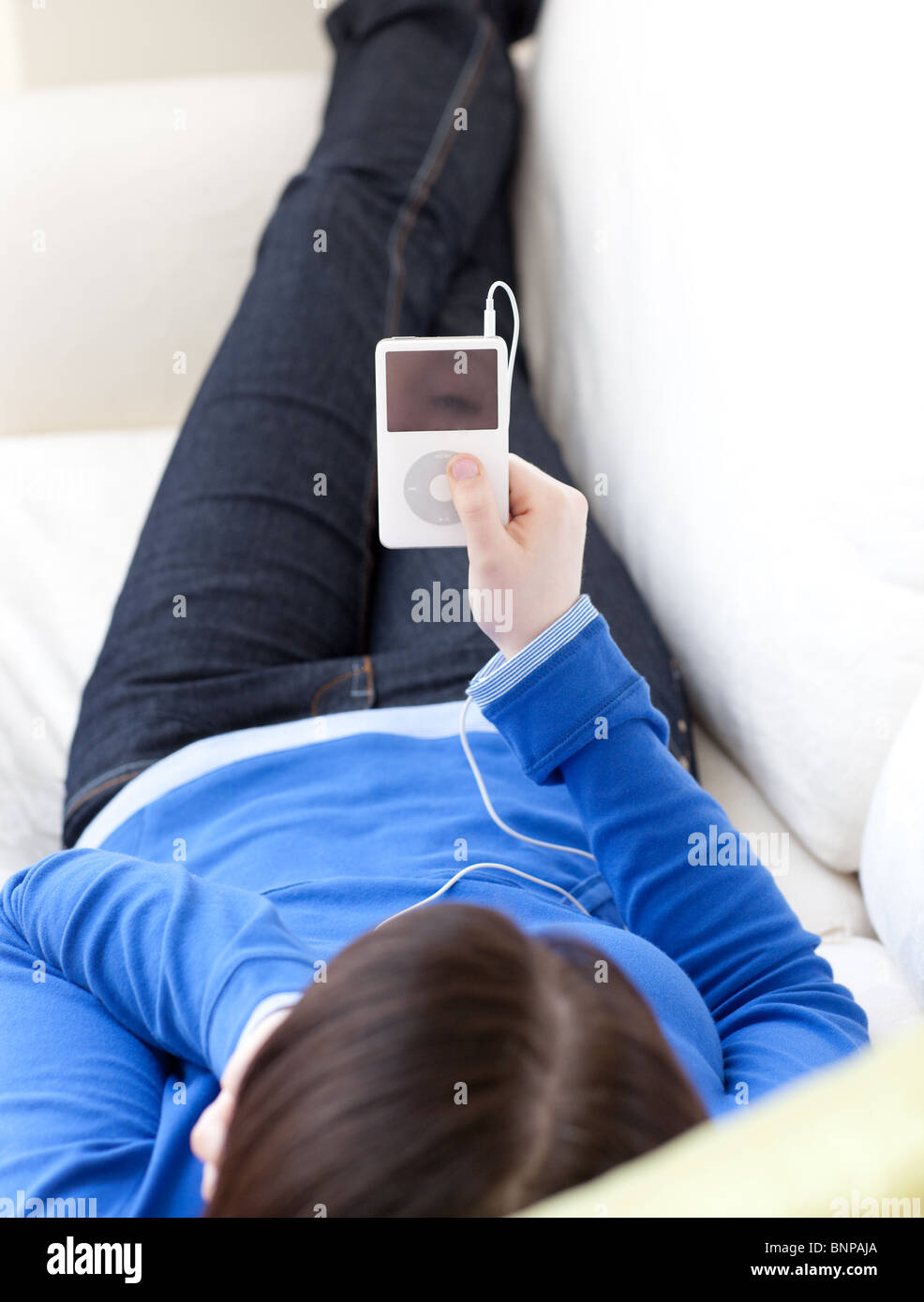Close-up of a teen girl listening music lying on a sofa Stock Photo - Alamy