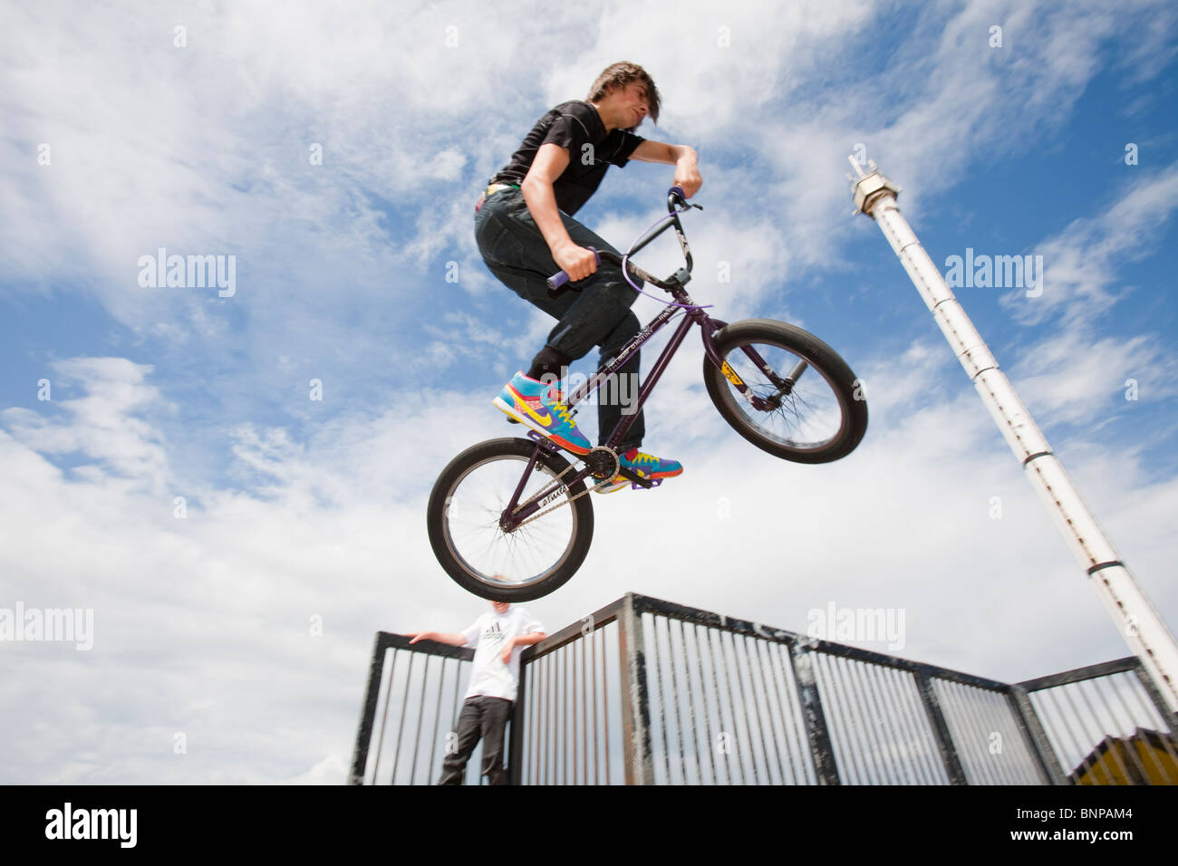 Teenage boys perform aerial stunts on BMX bikes at a BMX park in Rhyl